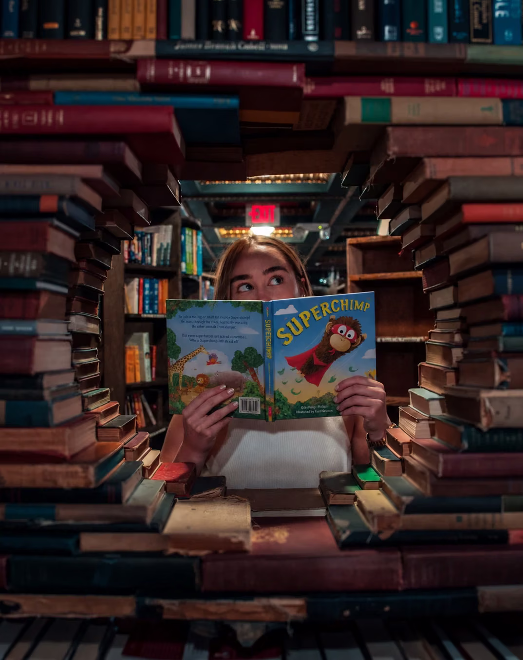 Victoria Vassiades in a bookshop, holding Superchimp, a picture book she designed
